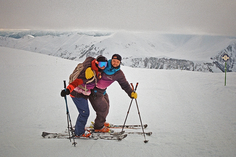 Two skiers embracing on the summit at Gudauri