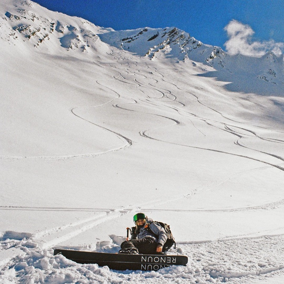 Snowboarder resting on the slope after a freeride run above Gudauri