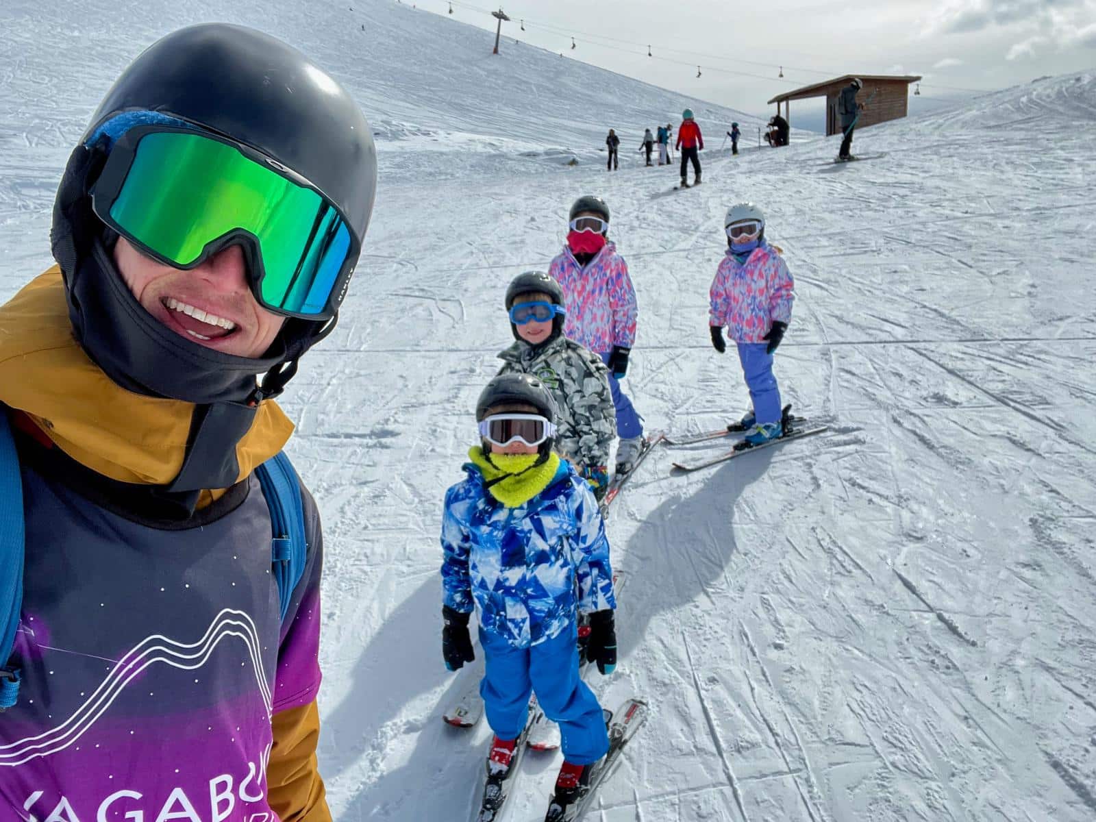Vagabond Ski School instructor taking a selfie with a group of young skiers on the slopes in Gudauri