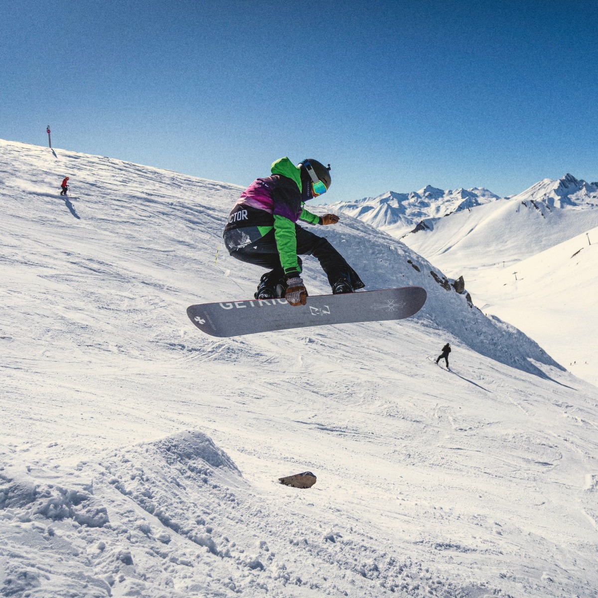 Snowboarder catching air off a jump above Gudauri